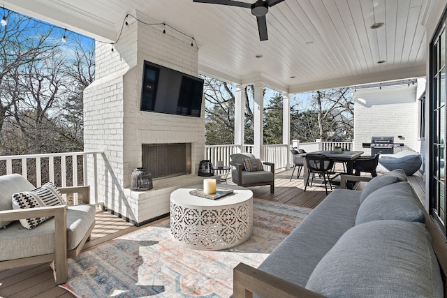 deck with an outdoor living space with a fireplace, a grill, and ceiling fan