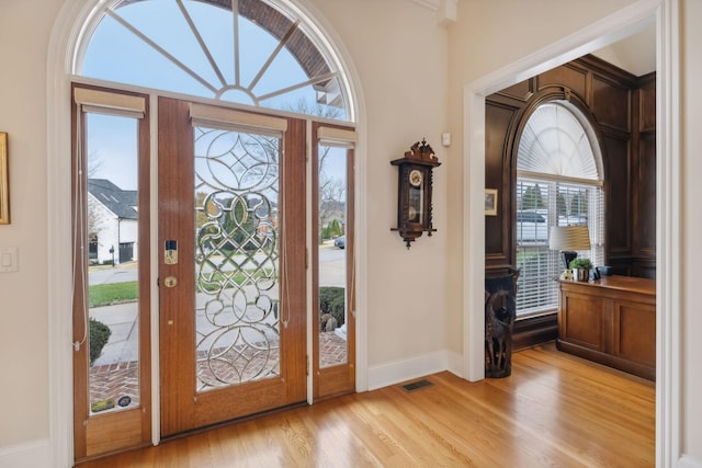 foyer featuring light wood-style flooring, visible vents, and baseboards