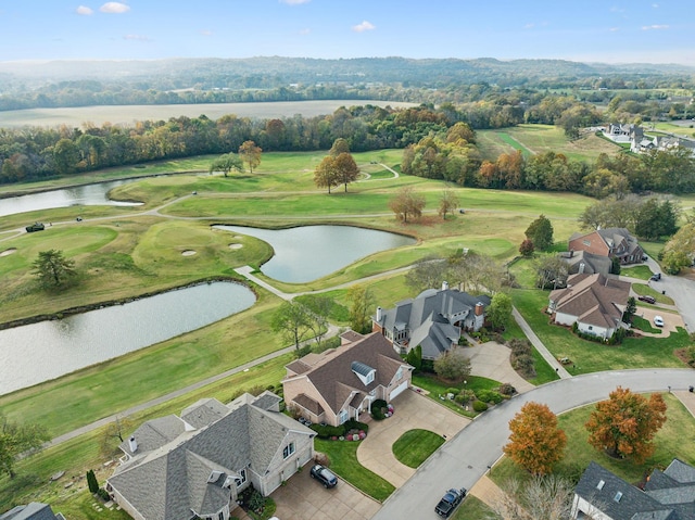 drone / aerial view with a water view, view of golf course, and a residential view