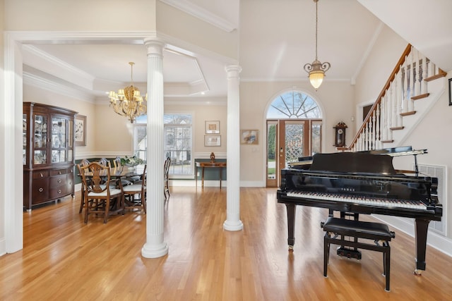 interior space featuring stairs, wood finished floors, decorative columns, and crown molding