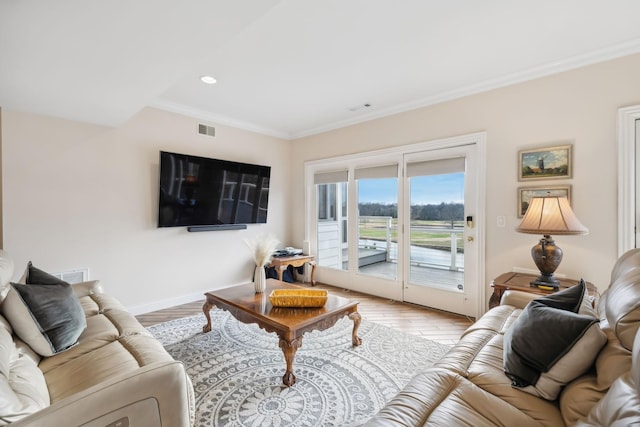 living area featuring ornamental molding, light wood-type flooring, visible vents, and baseboards