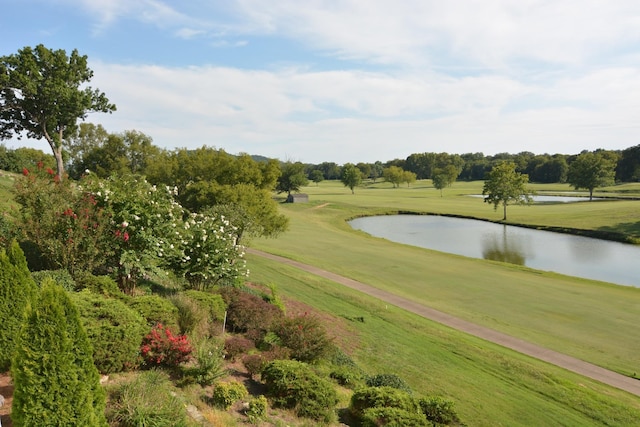 view of home's community with view of golf course, a water view, and a yard