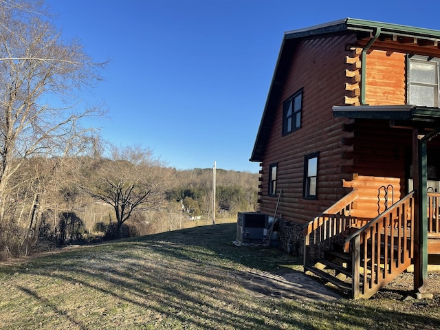 view of home's exterior with cooling unit and a lawn