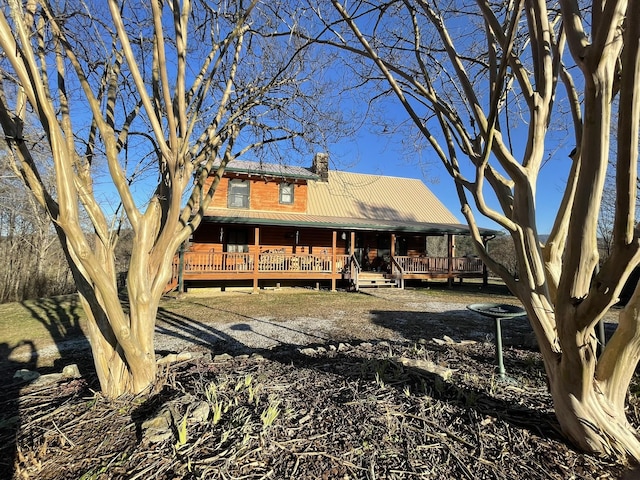 rear view of house featuring metal roof and a chimney