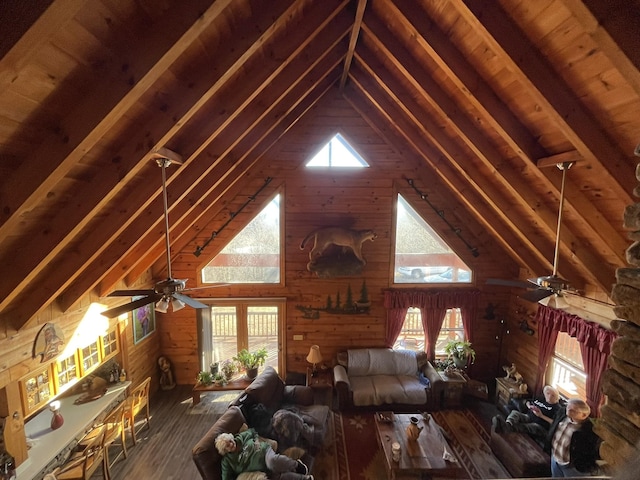 unfurnished living room with a wealth of natural light, beam ceiling, wooden walls, and wood finished floors