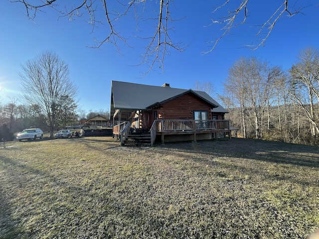 exterior space with log siding, a lawn, and a wooden deck