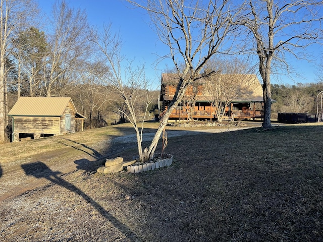 exterior space featuring a front yard, an outdoor structure, and a wooden deck