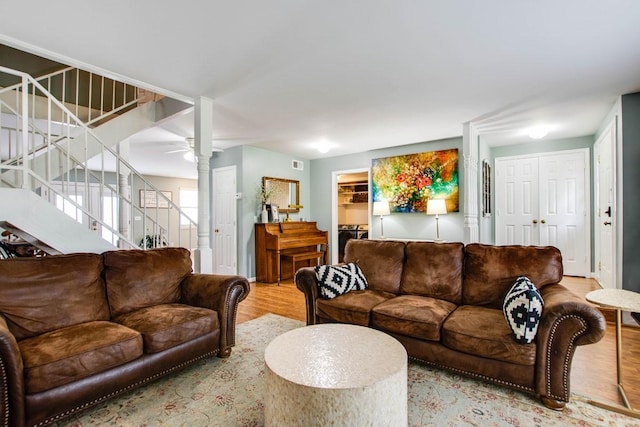 living room featuring light hardwood / wood-style floors, decorative columns, and ceiling fan