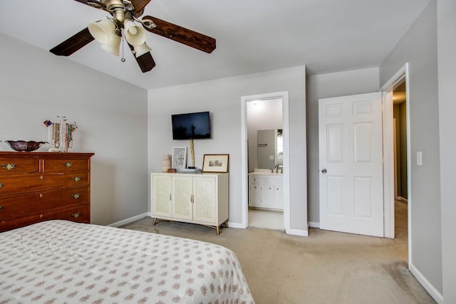 carpeted bedroom featuring ceiling fan, ensuite bath, and sink