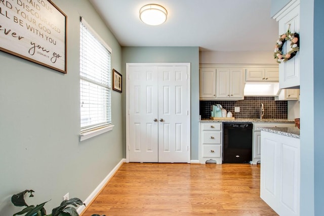 kitchen with white cabinetry, light hardwood / wood-style flooring, dishwasher, light stone countertops, and decorative backsplash