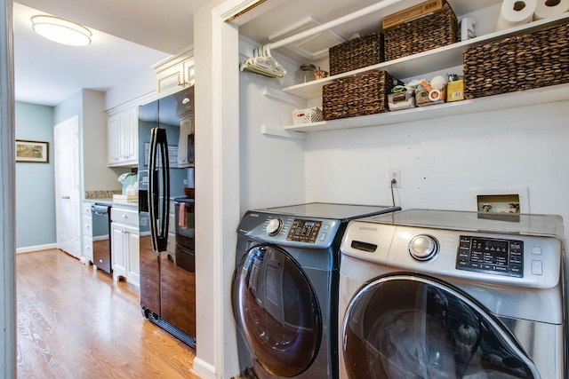 laundry room with independent washer and dryer and light hardwood / wood-style flooring