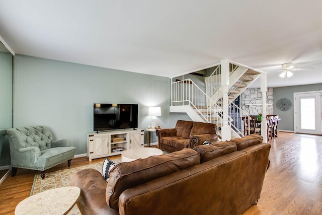 living room with light hardwood / wood-style flooring and ceiling fan