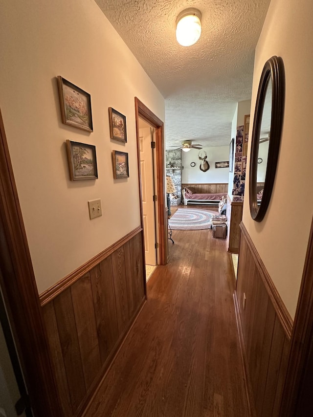 hallway with hardwood / wood-style floors and a textured ceiling