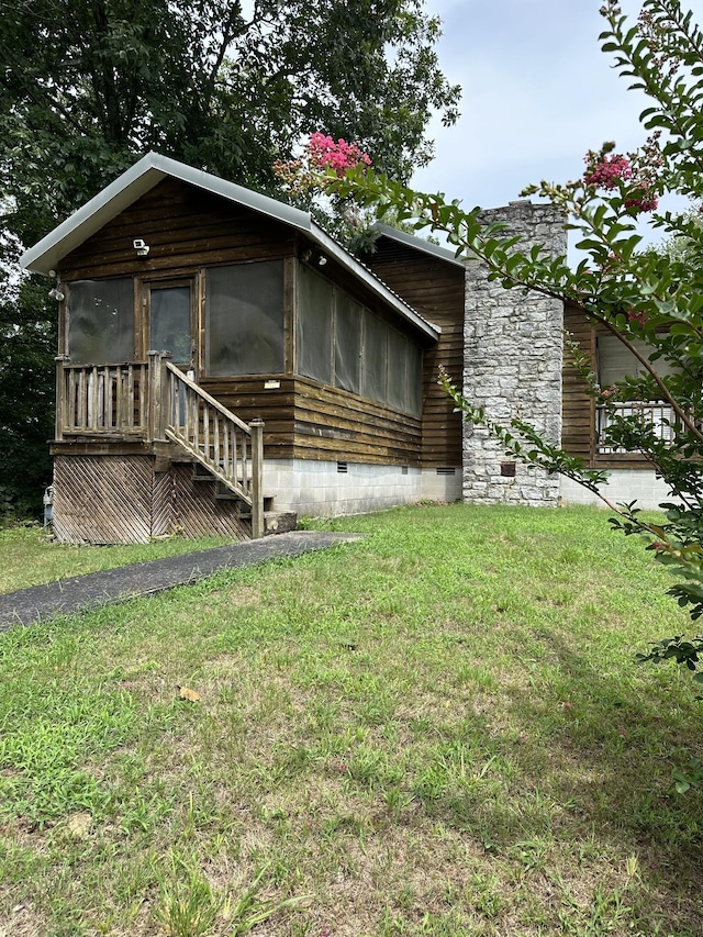 view of front facade featuring a sunroom and a front lawn