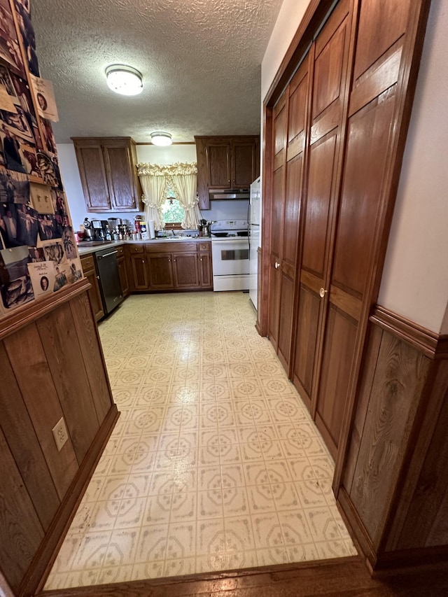 kitchen featuring dishwasher, sink, fridge, electric range, and a textured ceiling