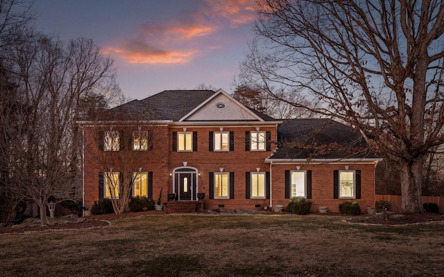 colonial-style house featuring a lawn