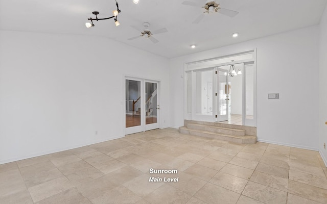 empty room featuring light tile patterned floors, ceiling fan with notable chandelier, and vaulted ceiling