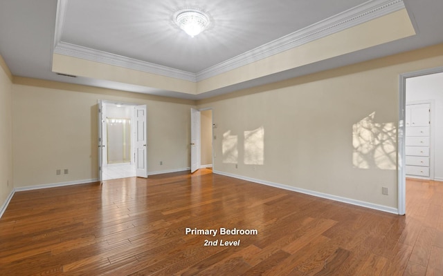 unfurnished room featuring crown molding, wood-type flooring, and a raised ceiling