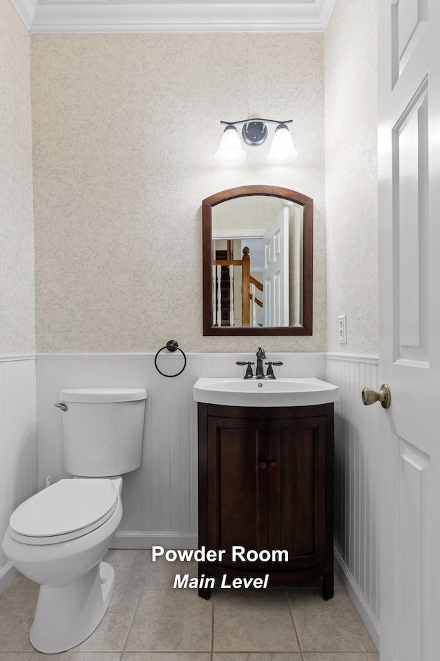 bathroom featuring vanity, tile patterned floors, crown molding, and toilet