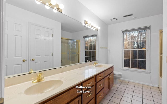 bathroom featuring vanity, toilet, a shower with shower door, and tile patterned flooring