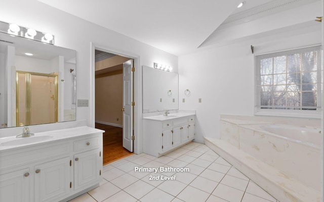 bathroom featuring vanity, vaulted ceiling, tile patterned floors, and shower with separate bathtub