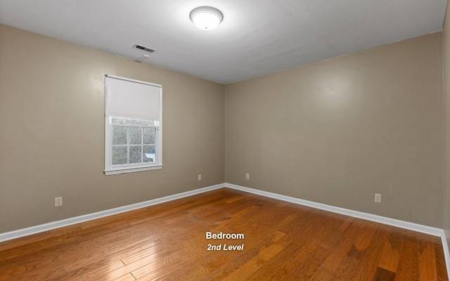 spare room with hardwood / wood-style flooring