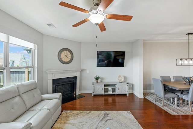 living room with dark wood-type flooring and ceiling fan