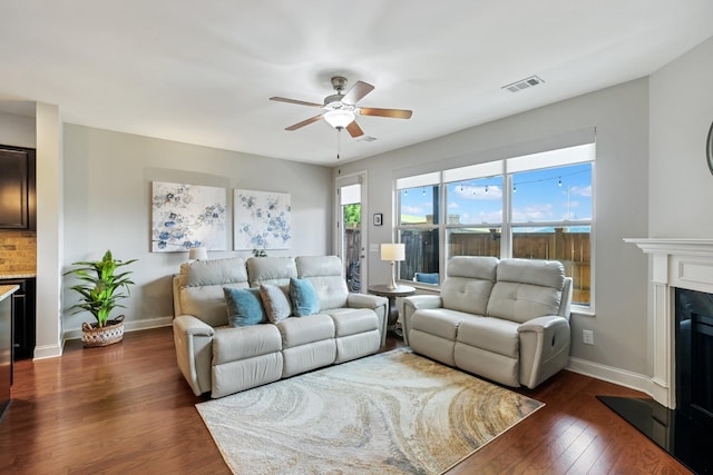 living room with ceiling fan and dark hardwood / wood-style flooring