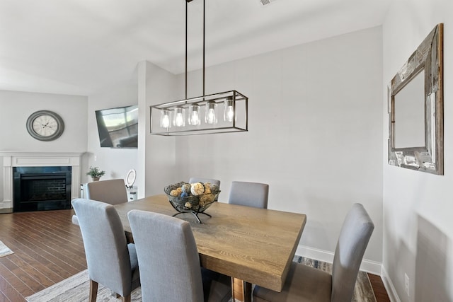 dining room featuring dark hardwood / wood-style flooring and a tile fireplace