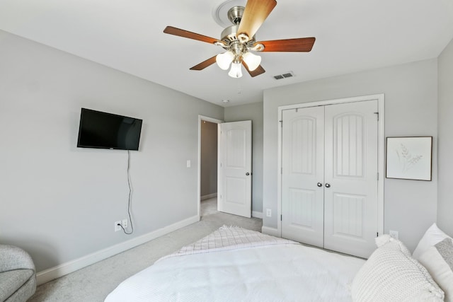 carpeted bedroom with ceiling fan and a closet