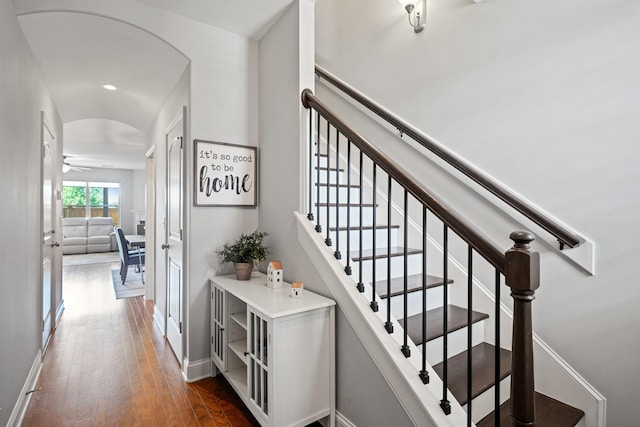 staircase with hardwood / wood-style flooring and ceiling fan