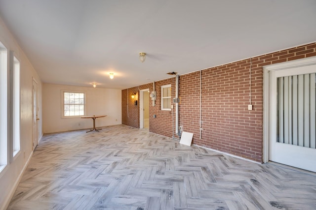 interior space with light parquet flooring and brick wall