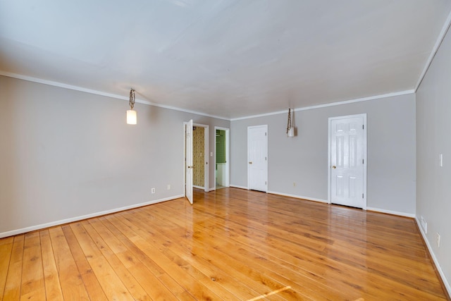 empty room featuring ornamental molding and hardwood / wood-style floors