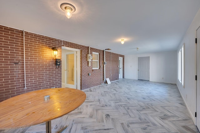 empty room featuring light parquet flooring and brick wall