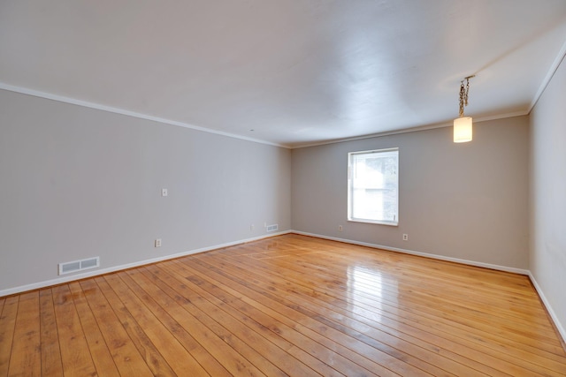 empty room featuring crown molding and light wood-type flooring