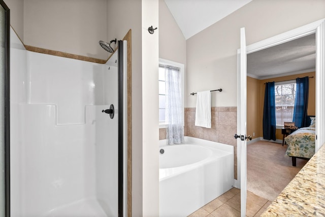 bathroom with vaulted ceiling, tile patterned floors, and shower with separate bathtub