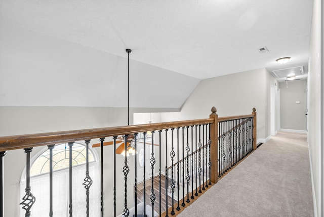 corridor featuring vaulted ceiling and carpet