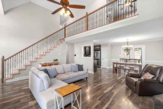 living room with a towering ceiling, ceiling fan with notable chandelier, ornamental molding, and dark hardwood / wood-style floors