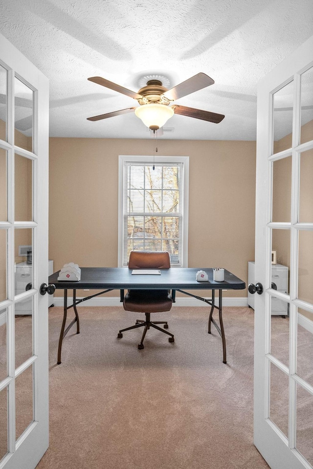 home office featuring french doors, light colored carpet, and a textured ceiling