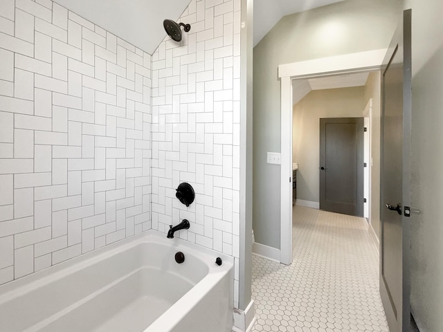 bathroom featuring tiled shower / bath, lofted ceiling, and tile patterned floors