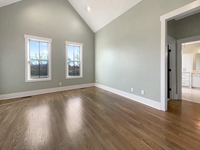 spare room featuring dark hardwood / wood-style floors and high vaulted ceiling