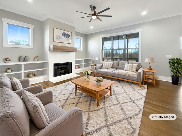 living room featuring wood-type flooring, ornamental molding, and ceiling fan