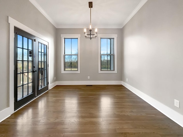 unfurnished dining area with ornamental molding, dark wood-type flooring, a chandelier, and french doors