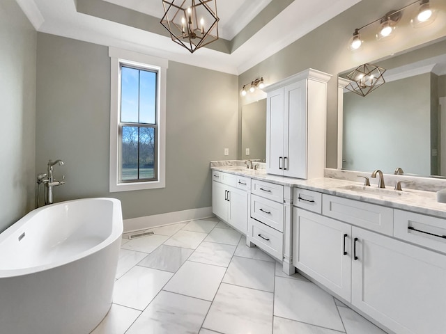 bathroom with vanity, a tray ceiling, a chandelier, and a washtub