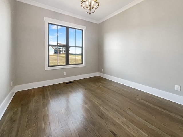 empty room featuring a notable chandelier, ornamental molding, and dark hardwood / wood-style floors