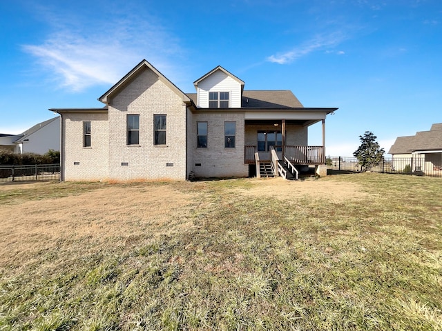 rear view of property featuring a lawn