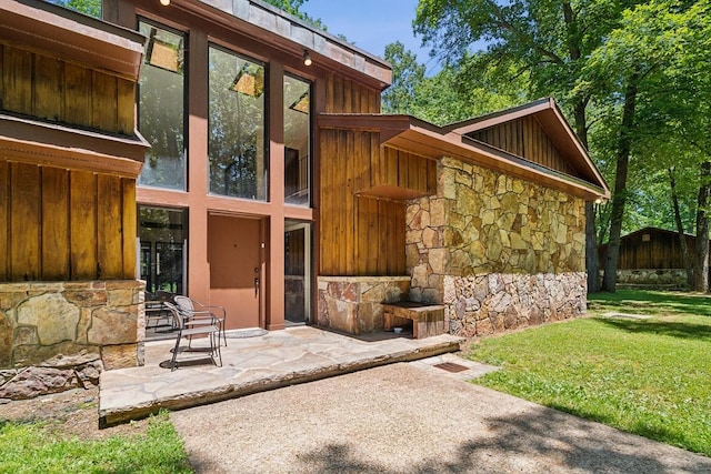 rear view of house featuring a patio and a lawn