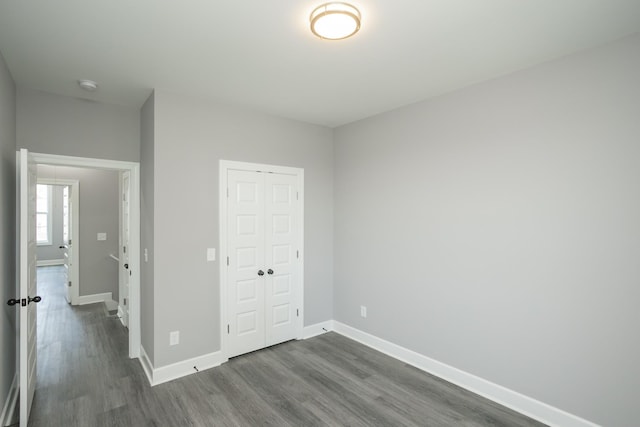 unfurnished bedroom featuring dark hardwood / wood-style floors and a closet