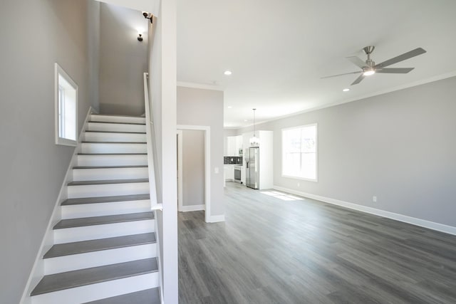 stairs with ornamental molding, hardwood / wood-style floors, and ceiling fan