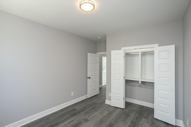 unfurnished bedroom featuring dark hardwood / wood-style flooring and a closet